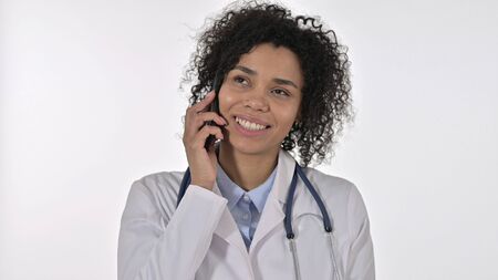 African Female Doctor using Smartphone, White Backgroundの写真素材