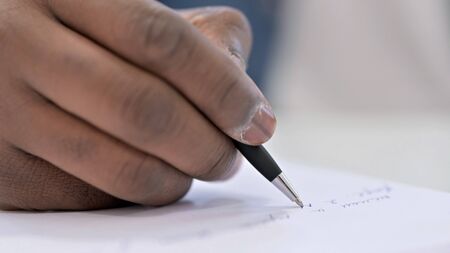 Close up Young African Man Hand writing on Paper