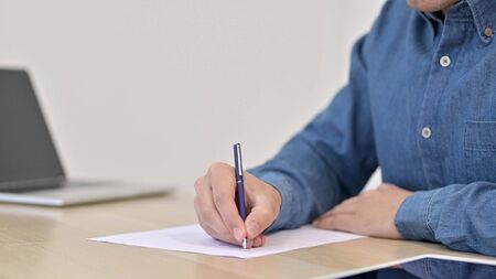 Male Hands Writing on Paper Close upの写真素材