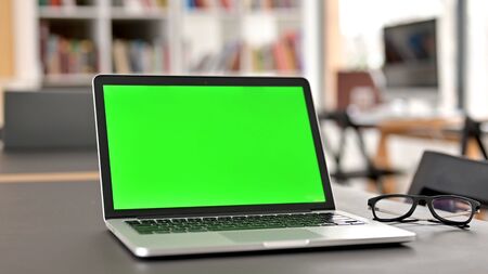 Modern Laptop with Chroma Screen Open on Tableの写真素材