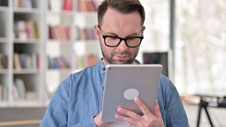 Young Man in Glasses Using Tabletの写真素材