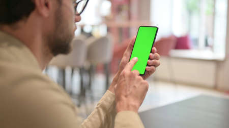 Young Man Browsing on Smartphone with Chroma Screen