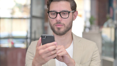 Portrait of Young Man Browsing on Smartphoneの写真素材