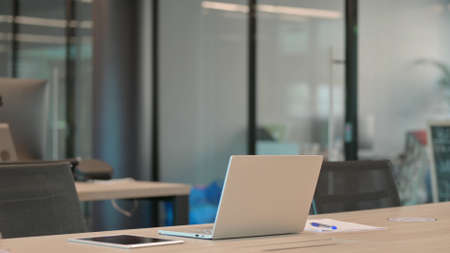 Empty Office with Open Laptop on Deskの写真素材
