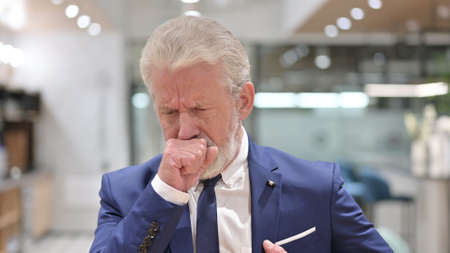 Portrait of Sick Old Businessman Coughingの写真素材