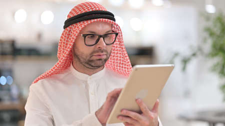 Portrait of Young Arab Man using Digital Tabletの写真素材