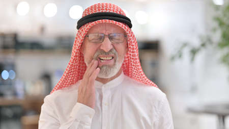 Portrait of Senior Old Arab Businessman having Toothache