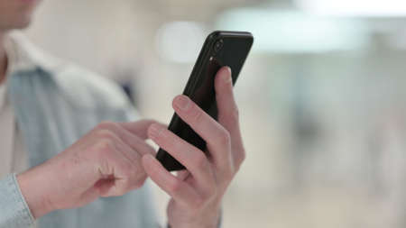 Close up of Man Browsing Internet on Smartphoneの写真素材