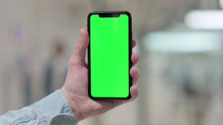 Close up of Hand Holding Smartphone with Green Screenの写真素材