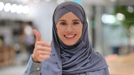 Portrait of Positive Arab Woman with Thumbs Up Signの写真素材