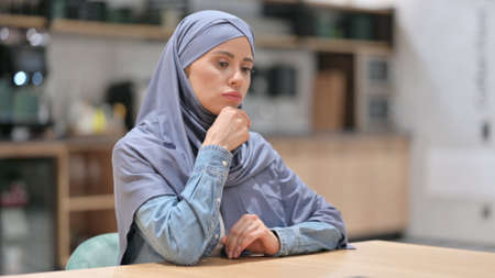 Pensive Arab Woman Sitting in Cafe, Thinkingの写真素材