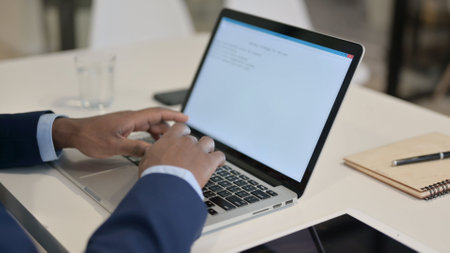 African Businessman Typing on Laptop in Office, Close up
