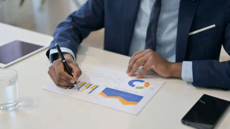 African Businessman Reading Charts on Paper, Paperworkの写真素材