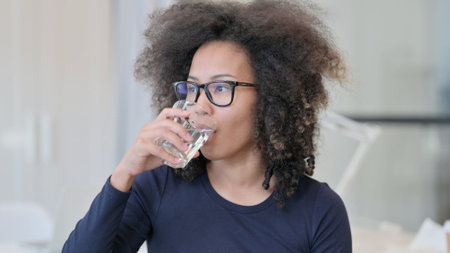 Thirsty African Woman Drinking Waterの写真素材