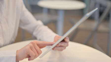 Close Up of Woman Hands Typing on Tablet, Side Viewの写真素材