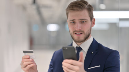 Young Businessman having Unsuccessful Online Payment on Smartphoneの写真素材