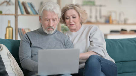 Old Couple Using on Laptop at Home