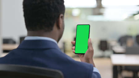 African Businessman Using Smartphone with Green Screenの写真素材