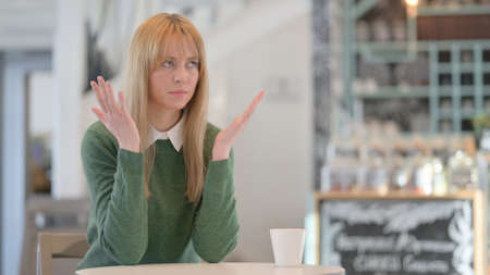 Woman Feeling Angry While Sitting in Cafeの写真素材