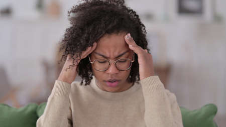 Young African Woman having Headache at Homeの写真素材