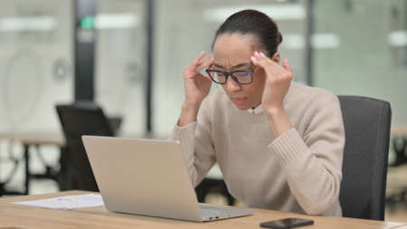 African Businesswoman with Laptop having Headache