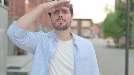 Man Looking Around, Searching while Standing Outdoorの写真素材