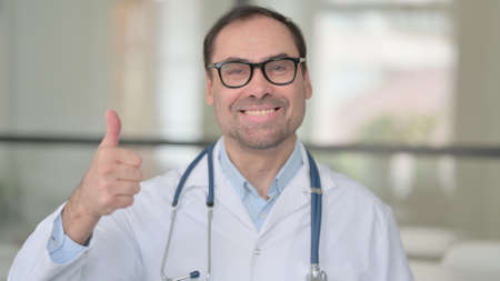 Middle Aged Doctor Showing Thumbs Up Signの写真素材