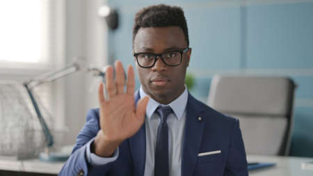 Portrait of African Businessman Showing Stop Sign by Handの写真素材