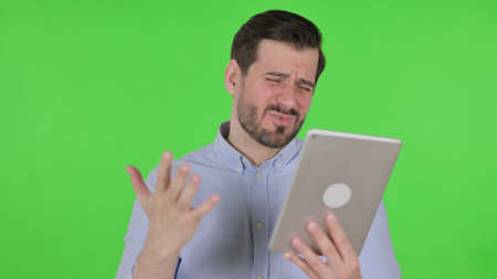 Portrait of Man having Loss on Tablet in Office, Green Screenの写真素材