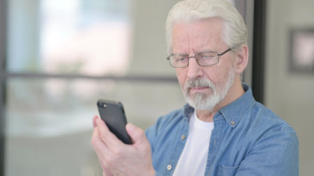 Old Man Browsing Internet on Smartphone