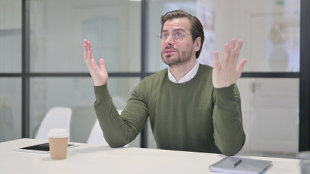 Upset Young Businessman Feeling Worried While Sitting in Office