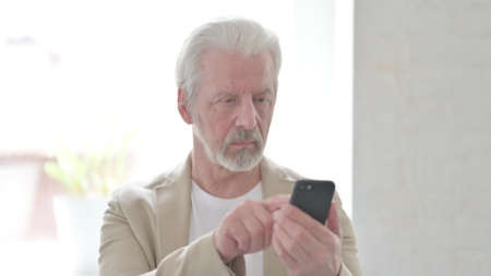 Old Man Browsing Internet on Smartphone