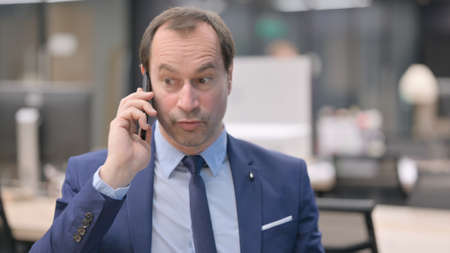 Portrait of Businessman Talking Angrily on Smartphoneの写真素材