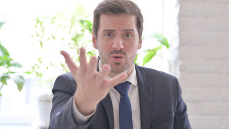 The Portrait of Angry Young Adult Businessman Fighting in Officeの写真素材