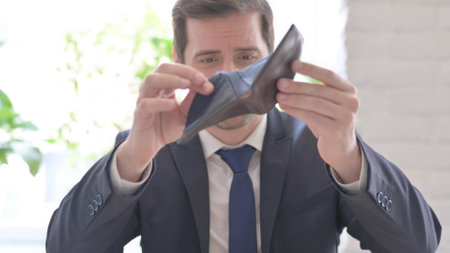 The Young Adult Businessman Searching Money in Empty Purse