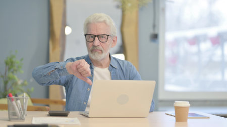 Senior Old Man Showing Thumbs Up while Working on Laptopの写真素材