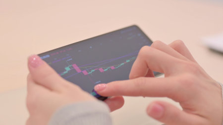 Woman Checking Trading Charts on Smartphone, Close Upの写真素材