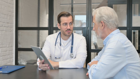Young Doctor Talking with Old Patient, Discussing Medical Report