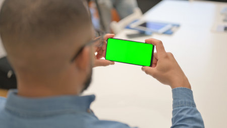 Hispanic Man Holding Phone Horizontal with Green Screen