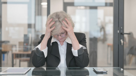Tense Senior Businesswoman Upset at Workの写真素材