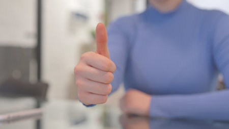 Close of Thumbs Up by Woman in Officeの写真素材