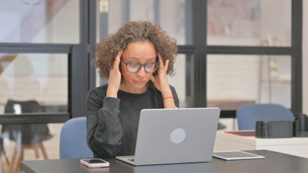 Mixed Race Woman having Headache at Workの写真素材