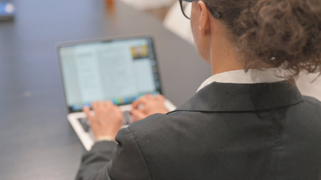 Rear View of Business Woman Typing on Laptopの写真素材