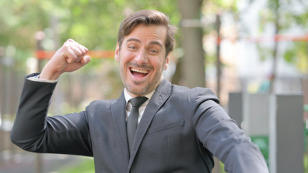 Portrait of Excited Young Businessman Cheering Outdoorの写真素材
