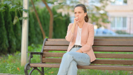 Casual Business Woman Coughing while Sitting Outdoor on Benchの写真素材