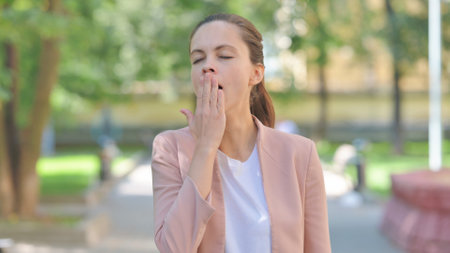 Portrait of Yawning Casual Business Woman Feeling Tired Outdoorの写真素材