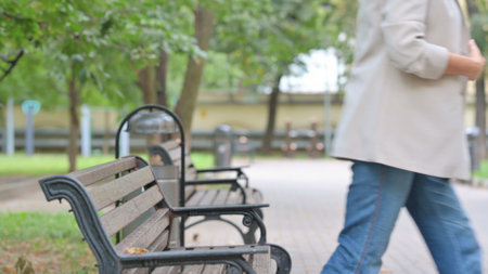 Old Woman Leaving Park after Sitting Outdoor on Bench