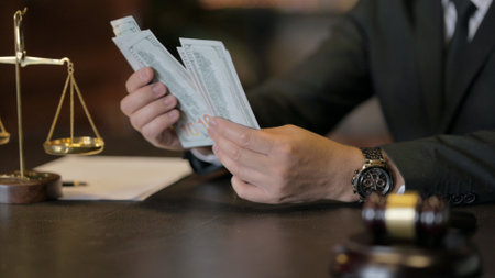 Close up of Hand Counting Money near Gavel in Courtroomの写真素材
