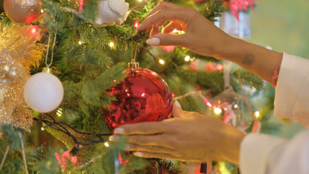 Close up of Woman Decorating Christmas Tree at Homeの写真素材