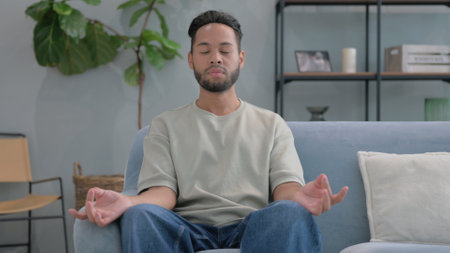Hispanic Man Doing Yoga at Homeの写真素材